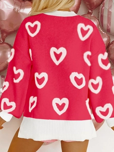Rear view of red knit sweater with white heart patterns and pink balloon background