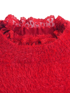 Gros plan d'un pull en peluche rouge avec dentelle et détails en mesh à pois