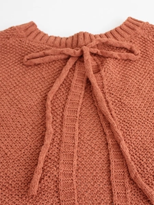 Close-up of brick red knit vest showing back lace-up bowtie detail and texture