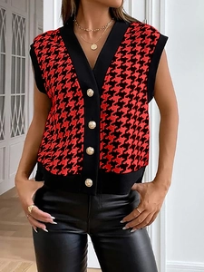 Dettaglio del gilet in maglia pied de poule rosso e nero con bottoni dorati