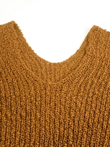 Detalle de cuello en V de jersey color caramelo con tejido de punto palomita