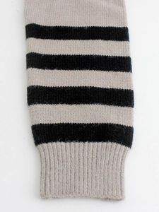 Detail of ribbed knit cuff with black and grey stripes on the sweater sleeve