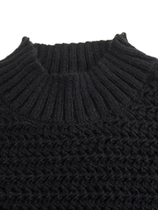 Close-up of black knit sweater featuring a ribbed mock neck and thick woven texture