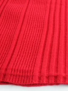 Makroaufnahme der roten Rippstrick-Textur des schulterfreien Pulloverkleides