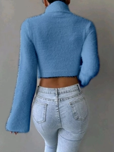 Back view of a blue cropped turtleneck sweater with fluffy knit mohair texture