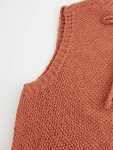 Detailed close-up of caramel knit sweater vest showing collar ribbing and texture