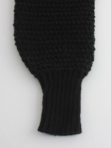 Detail of black knit sweater featuring wavy textured pattern and ribbed cuffs design
