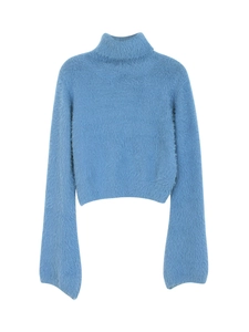Detail of light blue fuzzy turtleneck sweater showing soft texture and wide cuffs