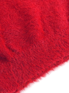 Gros plan détaillé du tissu en maille rouge pelucheux montrant une texture mohair douce