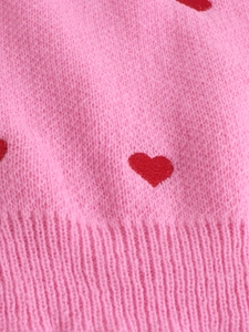 Dettaglio maglione in maglia mohair rosa con cuori rossi e trama a coste sul bordo