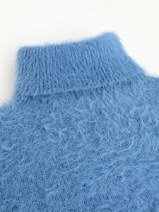 Detailed view of the ribbed turtleneck and soft plush texture on this blue sweater
