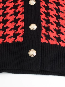Dettaglio gilet in maglia pied de poule rosso e nero con bottoni dorati a stemma