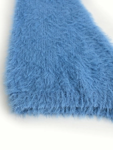 Close-up of fluffy royal blue faux fur fabric with soft long fibers for winter sweaters
