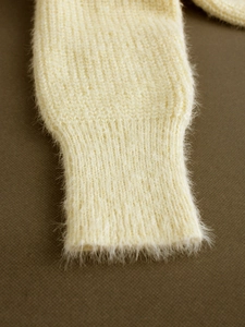 Close-up of soft cream knit sweater cuff featuring high-quality fuzzy mohair texture
