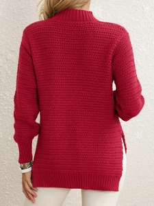 Detail view of deep red knit sweater featuring a high neck and stylish side slit hem