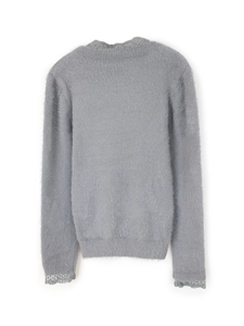 Détail d'un pull gris en maille avec dentelle délicate sur le col et les poignets
