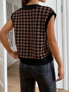 Dettaglio del gilet in maglia pied de poule marrone con bordi a coste e pantaloni di pelle