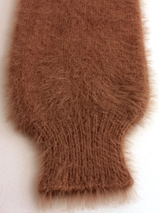 Detail of rust red long plush knit sleeve with ribbed cuffs showing soft texture