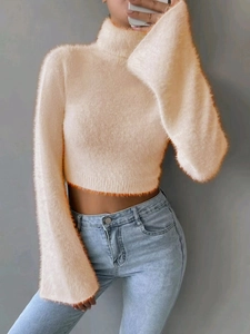 Close-up of beige turtleneck mohair sweater with orange contrast edge and fuzzy texture