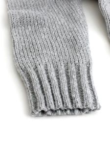 Detailed macro view of the ribbed cuffs on a grey V-neck knit sweater for women