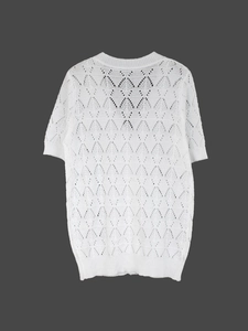 Detail of white hollow crochet knit top showing intricate geometric leaf patterns