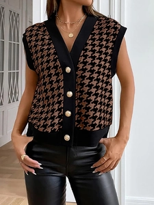 Dettaglio del gilet in maglia pied-de-poule con scollo a V e bottoni dorati di classe