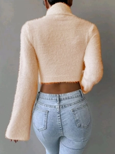 Detail of soft cream turtleneck sweater in fuzzy knit fabric with a back view pose