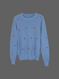 Close-up of light blue knit sweater featuring small American flag embroidery details