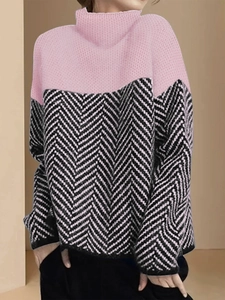 Detail eines rosa Strickpullovers mit schwarz-weißem Fischgrätmuster an Ärmeln und Saum