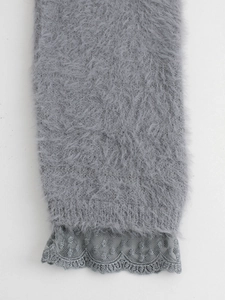 Détail de la texture en fausse fourrure grise et de la bordure en dentelle sur la manche
