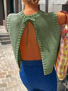 Detail of green knitted open back vest with a delicate bow tie on the back neck