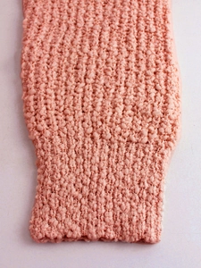 Primer plano detallado del jersey de punto rosa con textura de palomitas de maíz gruesa