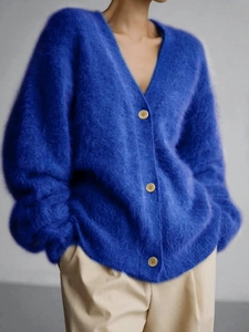 Macro view of bright blue knit cardigan featuring soft mohair texture and wooden buttons