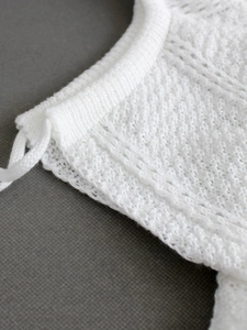 Robe de plage blanche en tricot avec motifs ajourés et détails de liens latéraux