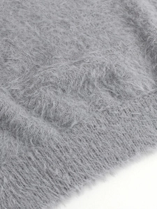 Détail rapproché d'un pull en maille grise à poils longs avec finition ourlet côtelé
