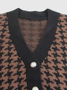 Dettaglio del gilet in maglia pied-de-poule con bottoni in metallo dorato a rilievo