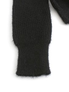 Detailed close-up of ribbed cuffs on a black mohair knit sweater with soft texture