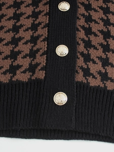 Dettaglio del gilet in maglia pied de poule marrone con bottoni stemma dorati