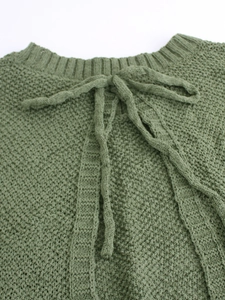 Detail of moss green knit sweater featuring a ribbed neckline and stylish bow tie-up design