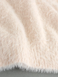 Macro shot of soft knit sweater fabric showing fluffy mohair texture in beige
