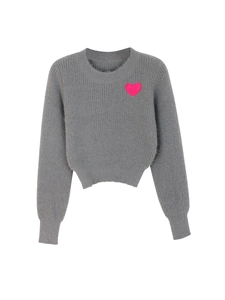 Detail of grey knit sweater showing soft texture and pink heart embroidery on the chest