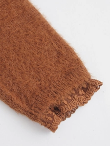 Gros plan détaillé des poignets en maille caramel avec empiècement en dentelle fine