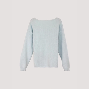 Dettaglio del maglione a maglia azzurro che mostra la trama a coste e i polsini