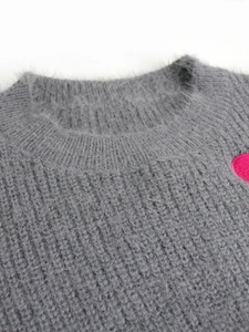 Close-up of knit sweater neck showing fuzzy grey fabric and pink heart embroidery