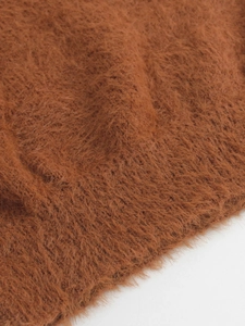 Détail rapproché du tricot marron caramel doux avec une texture pelucheuse