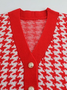Dettaglio scollo a V su gilet in maglia pied de poule rosso con bottone dorato a stemma