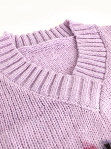 Close-up of lavender V-neck sweater showing fine ribbed knit texture and soft fabric