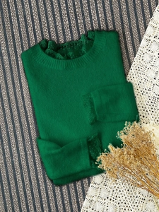 Vue détaillée du pull en maille vert foncé avec poignets et décolleté en dentelle fine