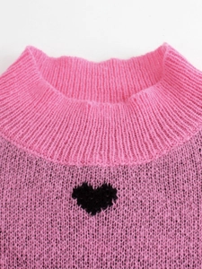 Pink knit heart sweater featuring a soft ribbed texture and elegant high neckline
