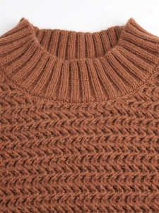 Detail of caramel brown knit sweater featuring round ribbed neckline and chevron pattern